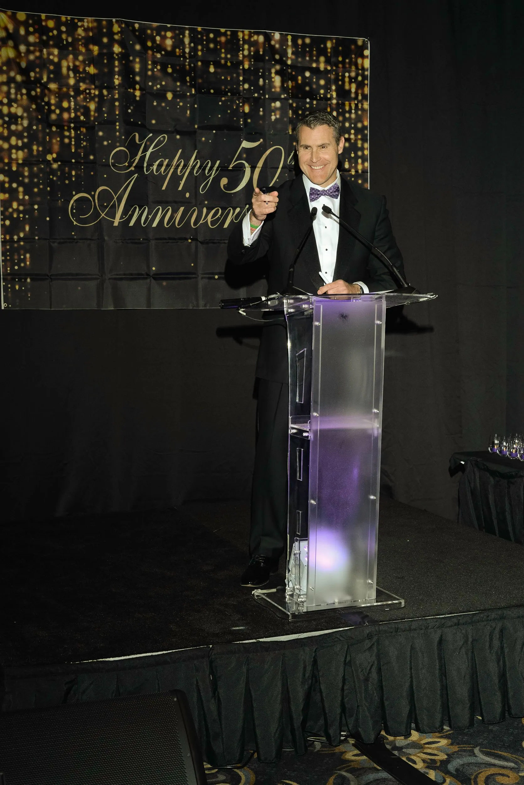 Steve Grandizio hosting an anniversary event from behind a clear podium